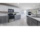 Updated kitchen with stainless appliances, gray lower cabinets, and mosaic tile backsplash at 6236 White Rabbit Pl, Indianapolis, IN 46235