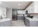 Bright kitchen features stainless steel appliances, white upper cabinets, and gray lower cabinets at 6236 White Rabbit Pl, Indianapolis, IN 46235