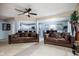 Spacious living room with ceiling fan, fireplace, and view to open kitchen and dining area at 6236 White Rabbit Pl, Indianapolis, IN 46235