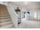 An entryway with stairs is next to a living room with neutral carpet and decor at 6236 White Rabbit Pl, Indianapolis, IN 46235