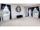 Neutral-toned living room with black accents, large windows, and tan carpeting at 6236 White Rabbit Pl, Indianapolis, IN 46235
