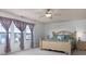 Bright main bedroom featuring large windows, ceiling fan, and decorative bed frame at 6236 White Rabbit Pl, Indianapolis, IN 46235