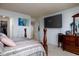 A spacious bedroom with a large screen tv on the wall and access to the stairway at 6236 White Rabbit Pl, Indianapolis, IN 46235