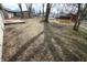 Spacious backyard with mature trees, grass, storage shed, and a wooden deck at 624 Park Dr, Greenwood, IN 46143