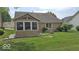 Exterior view of sunroom, lawn, shrubbery and chair in landscaped backyard at 6564 Aintree Pl, Indianapolis, IN 46250