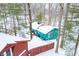 Aerial view of a teal house and a red outbuilding surrounded by snow-covered trees at 7166 N Oak Ridge Rd, Morgantown, IN 46160