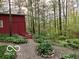 A rustic red barn with stone pathway among trees. Plenty of shade on a sunny day at 7166 N Oak Ridge Rd, Morgantown, IN 46160