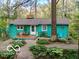 Charming turquoise home with a cozy front porch, surrounded by lush greenery and a stone pathway at 7166 N Oak Ridge Rd, Morgantown, IN 46160