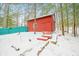 Red outbuilding with a teal fence surrounded by a snow covered landscape at 7166 N Oak Ridge Rd, Morgantown, IN 46160