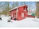 Exterior of a charming red outbuilding set amidst a snowy landscape at 7166 N Oak Ridge Rd, Morgantown, IN 46160