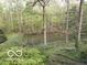 A serene pond surrounded by lush trees, offering a tranquil natural view, complete with manicured landscaping at 7166 N Oak Ridge Rd, Morgantown, IN 46160