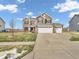 Beautiful, two-story home with brick and siding, a three-car garage, and manicured lawn at 976 Cherry Tree Ln, Greenwood, IN 46143