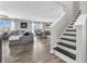 Inviting living room featuring sleek, modern stairs, plush gray sofa, and an open-concept layout at 976 Cherry Tree Ln, Greenwood, IN 46143