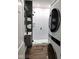 A cozy bathroom featuring a sleek, stacked washer/dryer, subway tile shower, and modern sink at 1046 Nelson Ave, Indianapolis, IN 46203