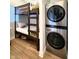 Efficient bedroom featuring a bunk bed and stacked washer and dryer, maximizing space and functionality at 1328 E Minnesota St, Indianapolis, IN 46203