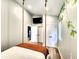 Bright bedroom features a suspended bed, wood-look floors, and a view of the closets and hallway at 1328 E Minnesota St, Indianapolis, IN 46203