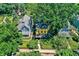 Aerial view showcasing a yellow house with manicured grounds surrounded by mature trees and neighboring blue home at 1409 N Park Ave, Indianapolis, IN 46202