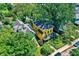 Aerial view of a bright yellow house nestled among mature trees, showcasing the property's lush surroundings and neighborhood charm at 1409 N Park Ave, Indianapolis, IN 46202