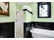 Vintage bathroom features clawfoot tub with handheld shower, black and white tile and decorative art at 1409 N Park Ave, Indianapolis, IN 46202