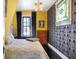 Stylish bedroom featuring dark trim, a decorative glass window, and yellow and black wallpaper at 1409 N Park Ave, Indianapolis, IN 46202