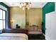Eclectic and decorative bedroom features a dark wood floor, gold accent wall, and antique decor at 1409 N Park Ave, Indianapolis, IN 46202