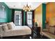 Eclectic green bedroom with gold accent wall, dark wood floors and antique decor at 1409 N Park Ave, Indianapolis, IN 46202
