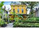 Charming yellow two-story home boasts beautifully landscaped front yard and inviting front porch at 1409 N Park Ave, Indianapolis, IN 46202