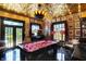 An elegant game room features a pool table, gold ceiling, dark floors, and many framed pictures at 1409 N Park Ave, Indianapolis, IN 46202