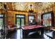 An elegant game room with a gilded tin ceiling boasts natural light and an elegant vintage style at 1409 N Park Ave, Indianapolis, IN 46202