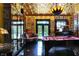 An elegant game room features a pool table, gold ceiling, dark floors, and many framed pictures at 1409 N Park Ave, Indianapolis, IN 46202