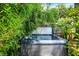Backyard hot tub surrounded by lush greenery and vibrant pink flowers, offering a private and tranquil outdoor retreat at 1409 N Park Ave, Indianapolis, IN 46202