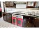 A stainless steel cooktop is installed above a red oven in this charming kitchen with black countertops at 1409 N Park Ave, Indianapolis, IN 46202