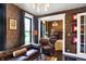 Stylish living room with patterned wallpaper, a comfortable leather sofa, and a view into a separate bedroom at 1409 N Park Ave, Indianapolis, IN 46202