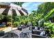 Cozy outdoor seating area with wicker furniture, an umbrella, and views of the inviting blue pool and lush tropical landscaping at 1409 N Park Ave, Indianapolis, IN 46202