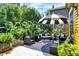 Inviting outdoor seating area on a wooden deck, complete with comfortable chairs, umbrella, and lush tropical plants at 1409 N Park Ave, Indianapolis, IN 46202
