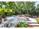 Outdoor patio with tables, chairs, an outdoor fireplace, and lush landscaping at 1409 N Park Ave, Indianapolis, IN 46202