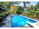 Beautiful backyard pool surrounded by greenery, lounge chairs, and a sunny patio area at 1409 N Park Ave, Indianapolis, IN 46202