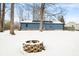 Backyard featuring a blue home, leafless trees, and a snow-covered fire pit at 150 W Jo Jo Ln, Nineveh, IN 46164