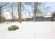 Winter backyard scene shows a home and a stone firepit surrounded by a blanket of fresh snow at 150 W Jo Jo Ln, Nineveh, IN 46164