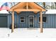 Inviting covered front entrance with stylish black door, wood accents and American flag in winter setting at 150 W Jo Jo Ln, Nineveh, IN 46164