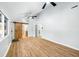 Open living room featuring wood floors, light walls, ceiling fans, and a barn door at 150 W Jo Jo Ln, Nineveh, IN 46164