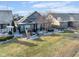Back exterior featuring a patio with seating, landscaped yard, screened-in porch, and a neatly maintained lawn at 15179 Kampen Cir, Carmel, IN 46033