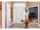 Inviting foyer featuring hardwood floors, front door with sidelights, and open doorway at 15179 Kampen Cir, Carmel, IN 46033