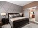 Luxurious main bedroom with sliding barn door to en-suite bathroom and accent wall at 15179 Kampen Cir, Carmel, IN 46033
