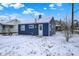 Blue home highlighting a snow-covered yard, perfect for serene outdoor living at 1651 Lawton Ave, Indianapolis, IN 46203