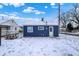 Rear view of the blue home with a spacious, snow-covered backyard and cozy picnic table at 1651 Lawton Ave, Indianapolis, IN 46203