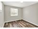 An empty bedroom with new vinyl plank flooring and two windows providing ample natural light at 1651 Lawton Ave, Indianapolis, IN 46203