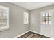 Bedroom with neutral walls, wood-look flooring, and natural light from windows and door at 1651 Lawton Ave, Indianapolis, IN 46203