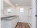 Bathroom features double vanity with granite countertop, framed mirror, and shower with glass doors at 18712 Moray St, Westfield, IN 46074