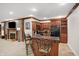 Basement bar area with granite countertop, wood cabinets, and bar stool seating at 2110 Cheviot Ct, Greenwood, IN 46143